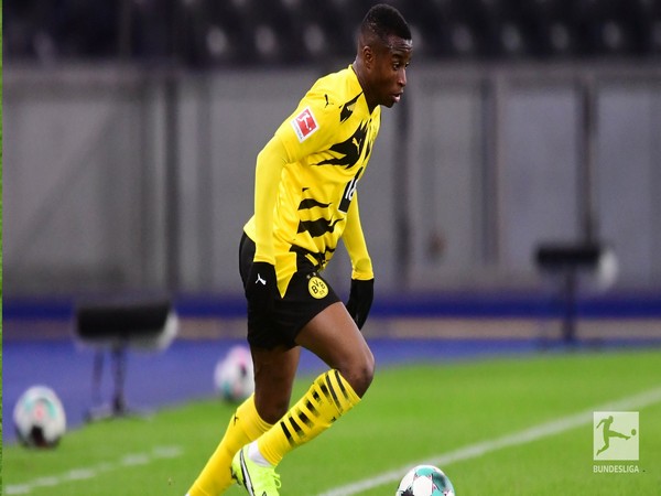 Soccer-Moukoko goal sends Dortmund top, Reus injured
