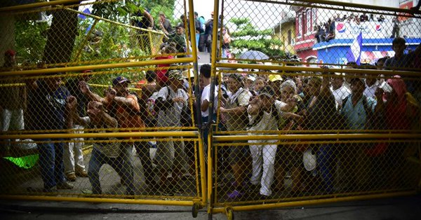 Migrants break border fence, enter Mexico despite police opposition