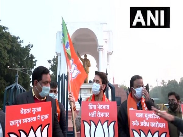 UP Polls: Anurag Thakur holds placard, BJP flag in Lucknow during election campaign
